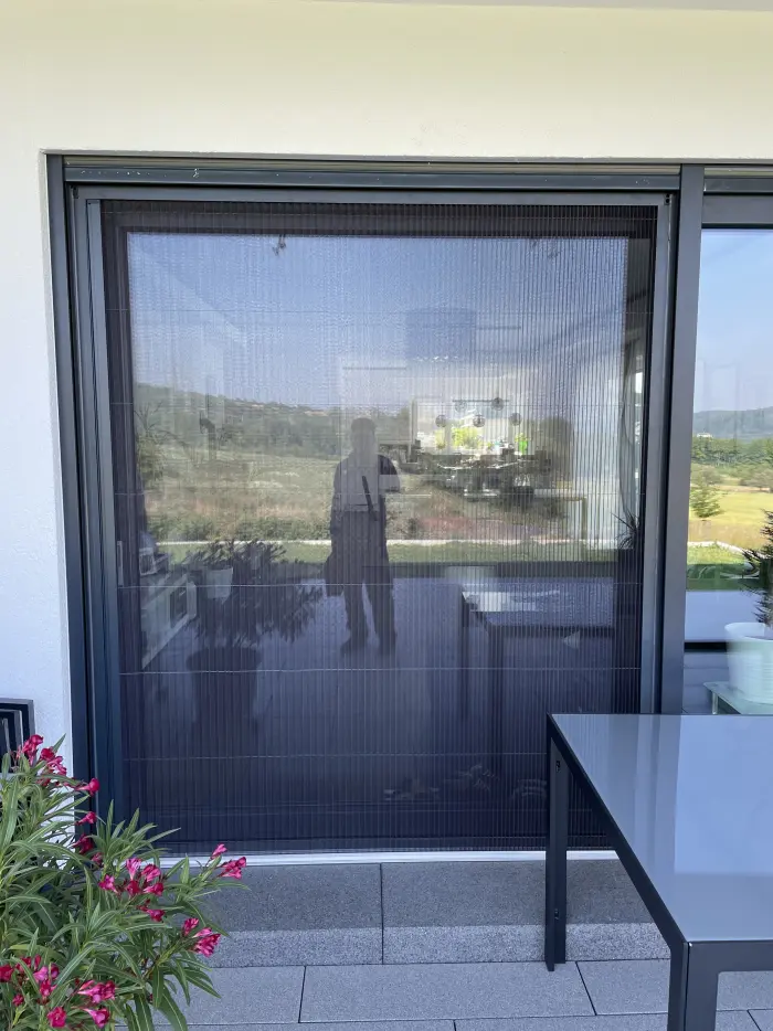 Insektenschutz-Plissee in Anthrazit an einer Terrassentür, Ansicht von der Terrasse